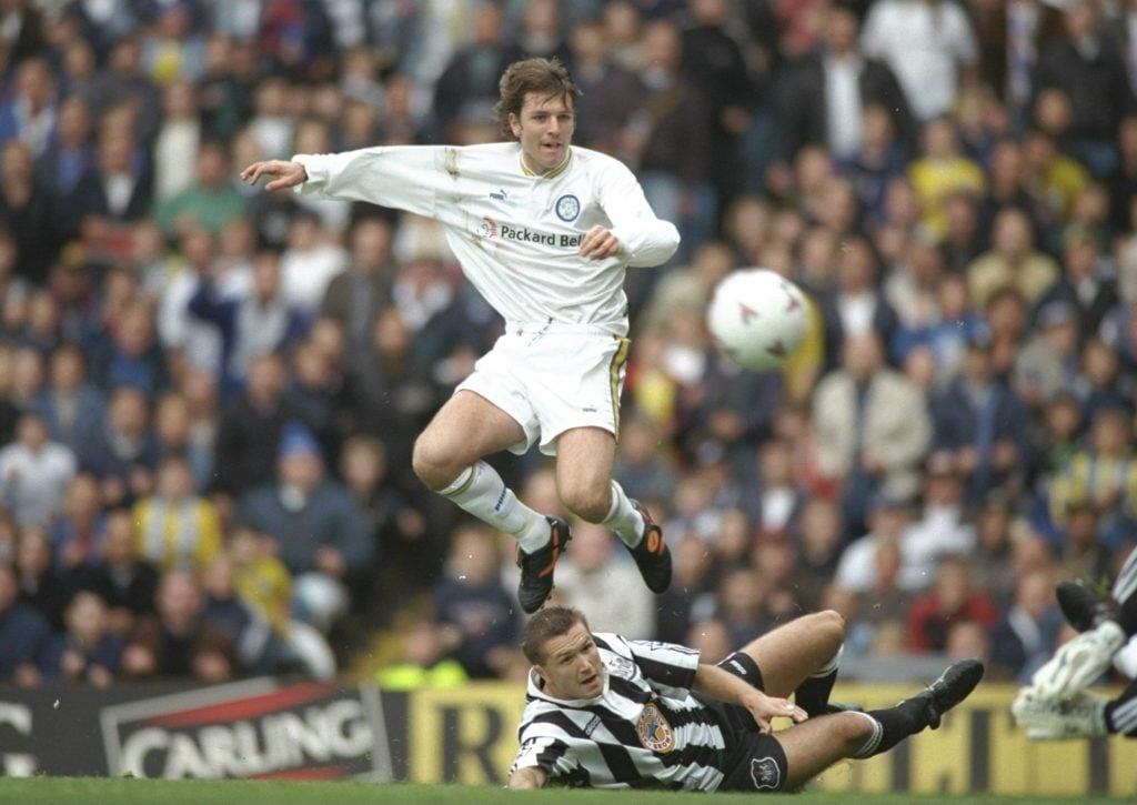 Lee Sharpe of Leeds United, off the groud, is tackled by Steve Howey