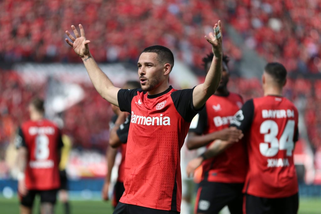 Emi Buendia holds his hands up in celebration for Bayer Leverkusen.