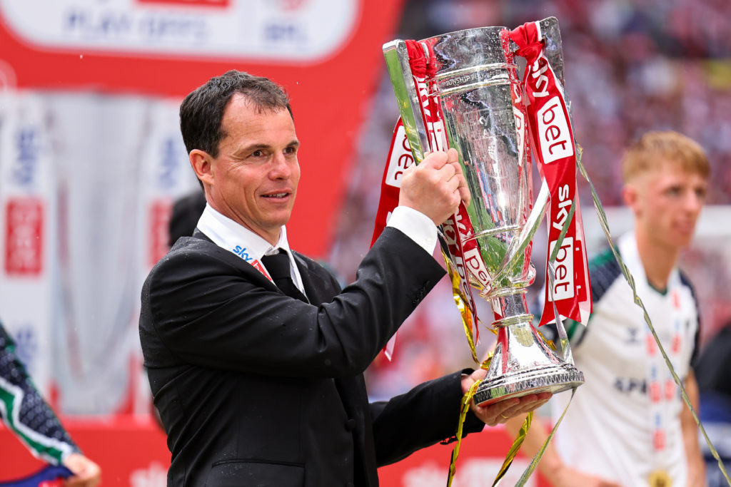 Regis Le Bris holds aloft the Championship play-off final trophy.