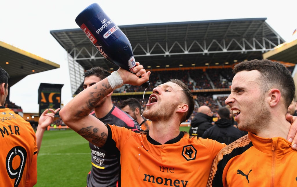 Barry Douglas drinks champagne with his arm around Diogo Jota while celebrating Wolves promotion in 2018.