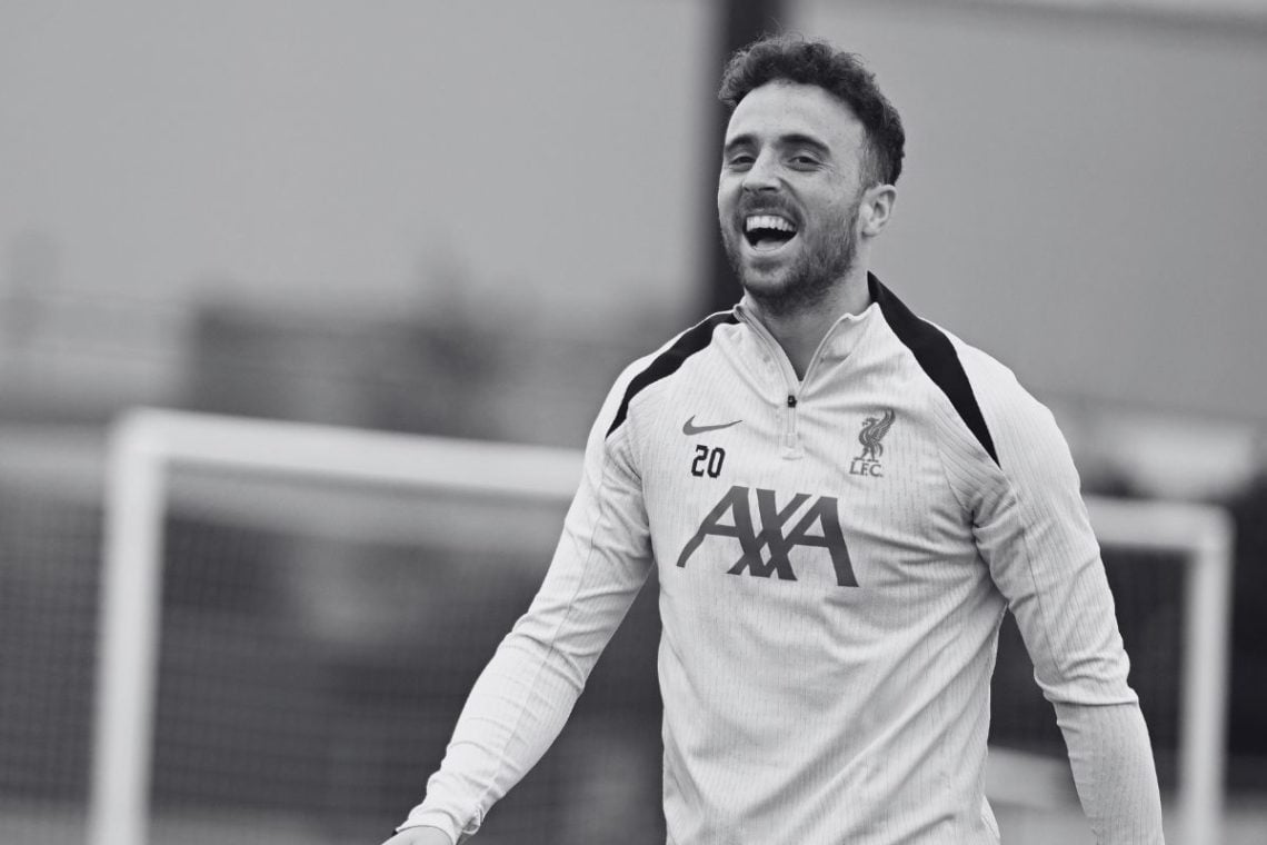 Black and white photo of Diogo Jota laughing in Liverpool training.