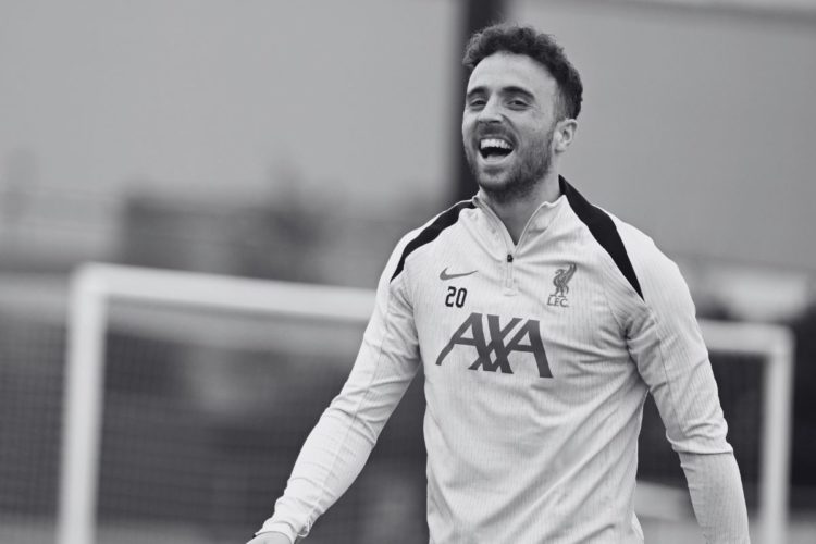 Black and white photo of Diogo Jota laughing in Liverpool training.