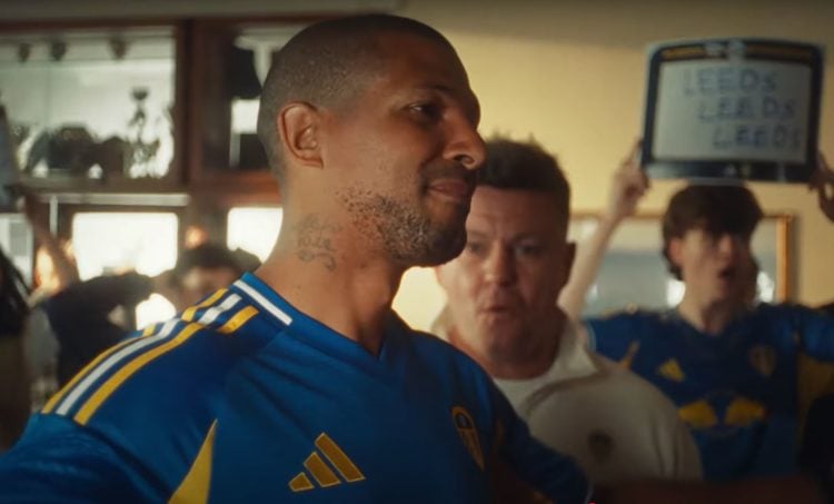 Jermaine Beckford models the 2025-26 Leeds United away kit in a pub from the official advert.