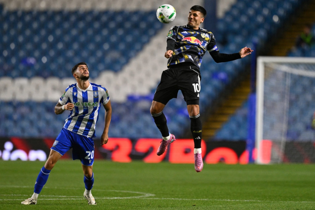Joel Piroe jumps to control a high ball for Leeds United.