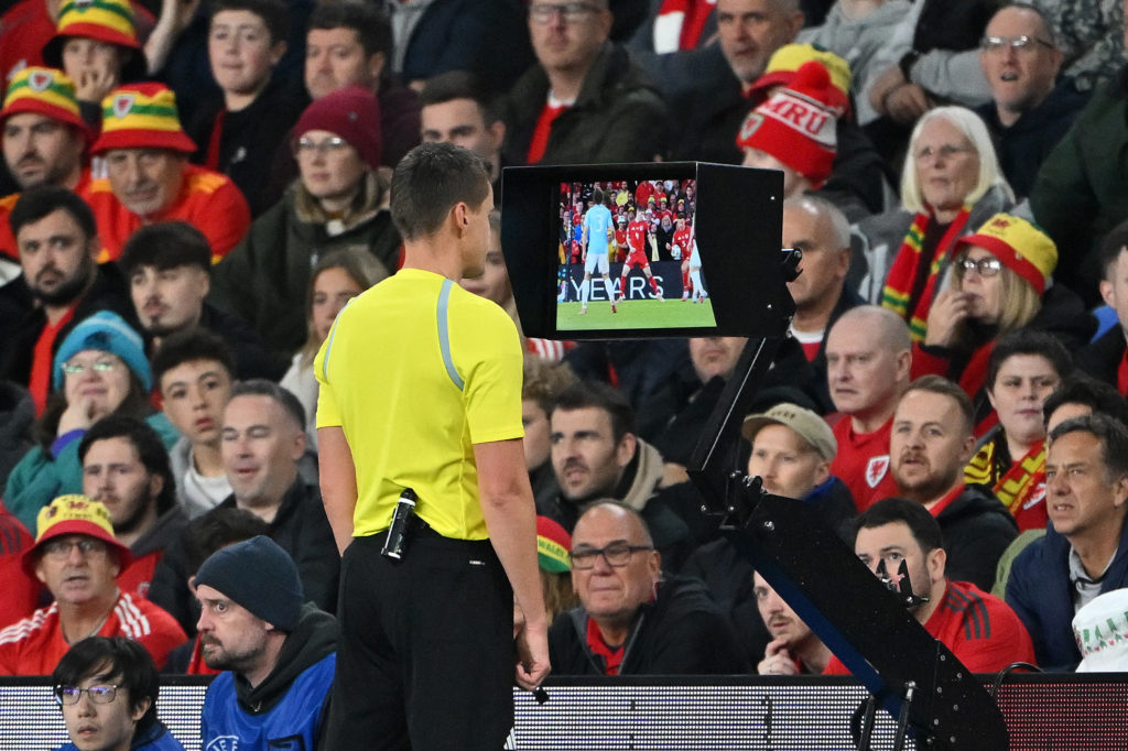 Referee checks a potential penalty against Ethan Ampadu for Wales